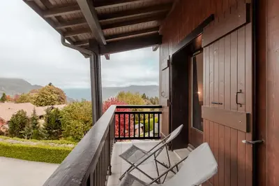 a balcony with chairs and a view of the mountains at Les Chaumes - T3 moderne piscine in Sallanches