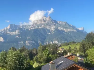 a mountain in the distance with houses and trees at Les Chaumes - T3 moderne piscine in Sallanches