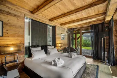 a bedroom with a large bed in a room with wooden walls at Megeve Luxury Estate The Royal Alpine Retreat with Mont Blanc View - Chalet Maille in Demi-Quartier