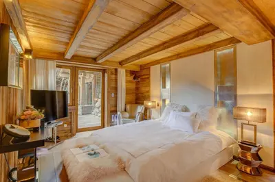 a large bedroom with a large bed and a television at Megeve Luxury Estate The Royal Alpine Retreat with Mont Blanc View - Chalet Maille in Demi-Quartier