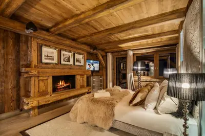 a log cabin bedroom with a fireplace and a bed at Megeve Luxury Estate The Royal Alpine Retreat with Mont Blanc View - Chalet Maille in Demi-Quartier