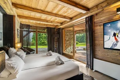 two beds in a room with a large tv at Megeve Luxury Estate The Royal Alpine Retreat with Mont Blanc View - Chalet Maille in Demi-Quartier