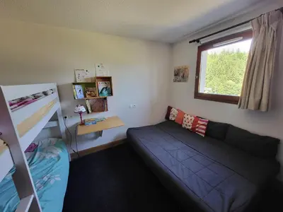 a bedroom with a couch and a bunk bed at Jardins Alpins A N 20 - 2P6 in Morillon