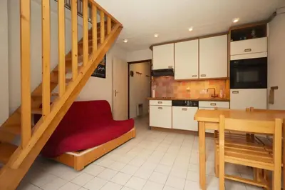 a living room with a staircase and a kitchen at Résidence Les Chamois - Les Chamois MAE-0143 in Les Houches