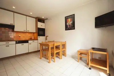 a kitchen with white cabinets and a table and chairs at Résidence Les Chamois - Les Chamois MAE-0143 in Les Houches