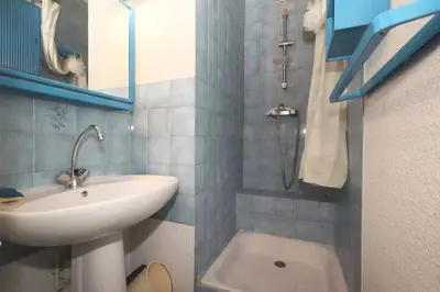 a blue tiled bathroom with a sink and a shower at Résidence Les Chamois - Les Chamois MAE-0143 in Les Houches