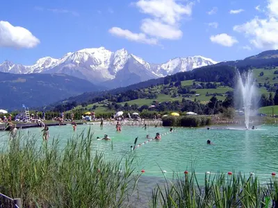 a group of people swimming in a lake with mountains at Appartement 10 personnes au pied des pistes vue Mont Blanc in Combloux