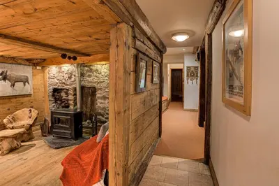 a living room with a wooden wall and a fireplace at Chalet Pele - Alpes Travel - Sleeps 11 in Chamonix-Mont-Blanc