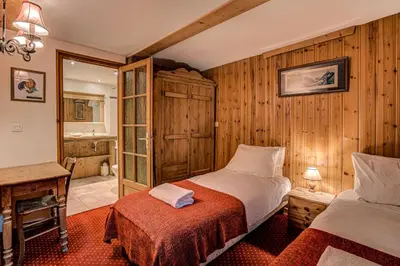 a bedroom with two beds and a bathroom at Chalet Pele - Alpes Travel - Sleeps 11 in Chamonix-Mont-Blanc