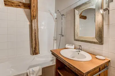 a bathroom with a sink and a tub and a mirror at Chalet Pele - Alpes Travel - Sleeps 11 in Chamonix-Mont-Blanc