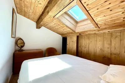a bedroom with a large bed with a skylight at Le 2ème Ciel in Megève
