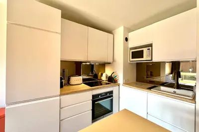 a white kitchen with white cabinets and appliances at Le 2ème Ciel in Megève