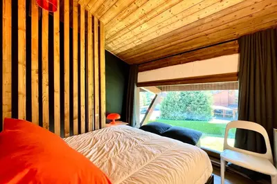 a bedroom with a bed and a large window at Le 2ème Ciel in Megève