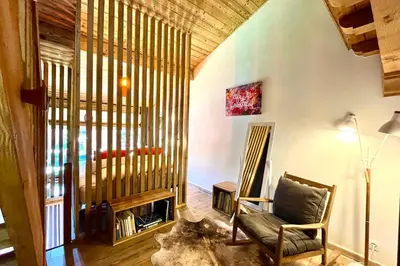 a living room with a chair and a fireplace at Le 2ème Ciel in Megève