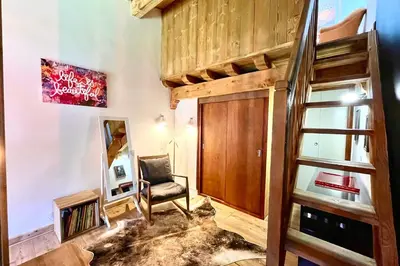 a room with a loft bed and a chair at Le 2ème Ciel in Megève