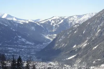 a snowy mountain range with a town in the valley at L'appart 313 - La Forclaz in Chamonix-Mont-Blanc