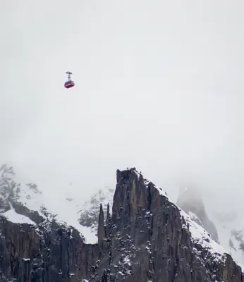 a helicopter flying over a mountain in the snow at L'appart 313 - La Forclaz in Chamonix-Mont-Blanc