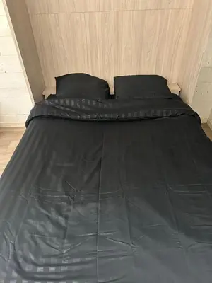a bed with a black comforter and two pillows at L'appart 313 - La Forclaz in Chamonix-Mont-Blanc