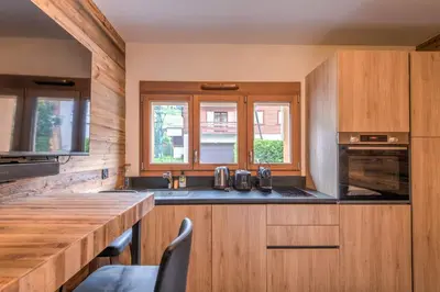a kitchen with wooden cabinets and a wooden counter top at Studio Berrier - Welkeys in Megève