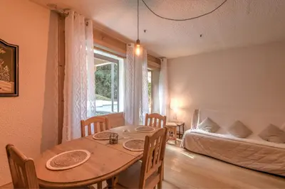a dining room with a table and a couch at Appartement Vinson - Welkeys in Megève