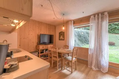 a kitchen and dining room with a table and a window at Appartement Vinson - Welkeys in Megève