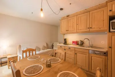 a kitchen with a wooden table and a dining room at Appartement Vinson - Welkeys in Megève