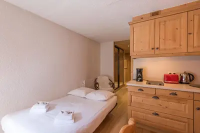 a bedroom with a bed and a dresser at Appartement Vinson - Welkeys in Megève