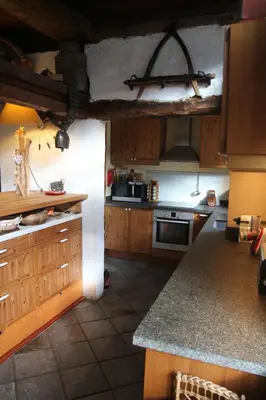 a kitchen with wooden cabinets and a stove top oven at Nos Maisons Cosy - Vallorcine in Vallorcine