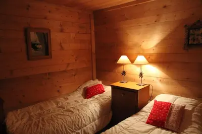 a bedroom with two beds in a log cabin at Nos Maisons Cosy - Vallorcine in Vallorcine