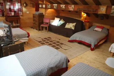 a bedroom with two beds and a couch in a room at Nos Maisons Cosy - Vallorcine in Vallorcine