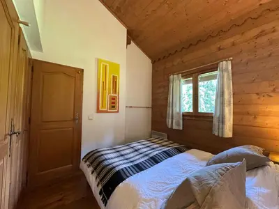 a bedroom with a bed in a wooden cabin at Appartement confortable au pied des pistes pour 8 personnes - FR-1-642-104 in Morillon
