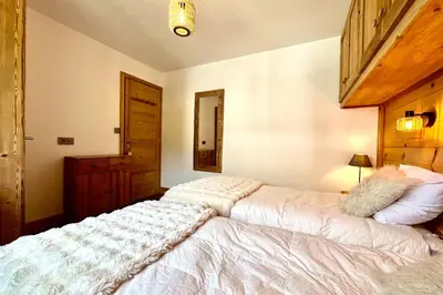 a bedroom with two beds and a mirror at Refuge de la Fontaine in Megève