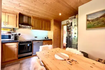 a kitchen with a wooden table in a room at Refuge de la Fontaine in Megève