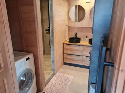 a bathroom with a washing machine and a sink at Gîte de l Auguille in Megève