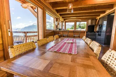 a dining room with a large wooden table and chairs at Modern Chalet Near Megève With Somptuous Views in Combloux