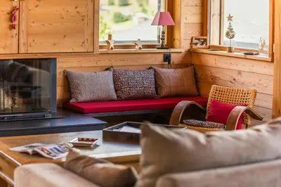 a living room with a couch and a fireplace at Modern Chalet Near Megève With Somptuous Views in Combloux