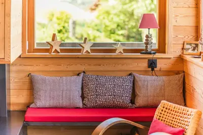 a bench with four pillows sitting in front of a window at Modern Chalet Near Megève With Somptuous Views in Combloux