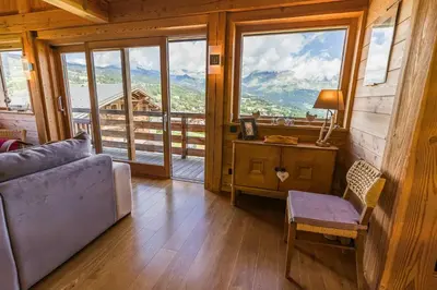 a living room with a couch and a large window at Modern Chalet Near Megève With Somptuous Views in Combloux