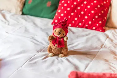a teddy bear sitting on top of a bed at Modern Chalet Near Megève With Somptuous Views in Combloux