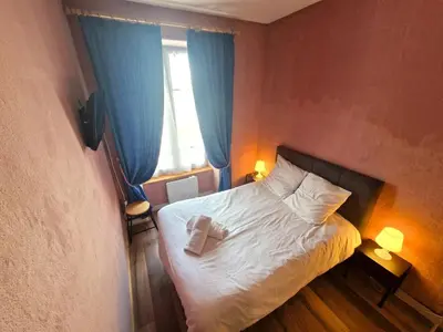 a bedroom with a bed and a window with blue curtains at Appartement Lyret, Chamonix Centre, 4 personnes in Chamonix-Mont-Blanc