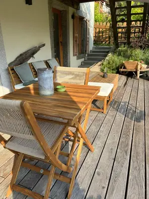 a wooden table and chairs on a wooden deck at Le point de vue in Chamonix-Mont-Blanc