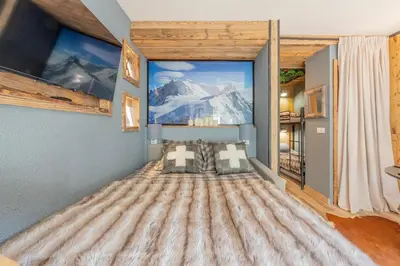 a bedroom with a large window with a mountain view at Chalet studio Megève enface des remontées mécaniques et parking gratuit in Demi-Quartier