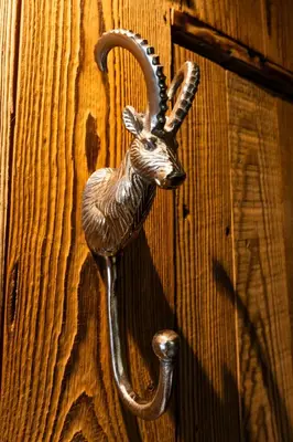 a door knob with a gazelle head on a wooden door at Chalet studio Megève enface des remontées mécaniques et parking gratuit in Demi-Quartier