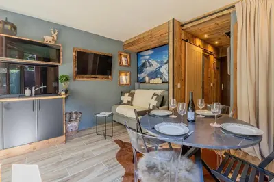 a bedroom with a bed and a desk and a table at Chalet studio Megève enface des remontées mécaniques et parking gratuit in Demi-Quartier