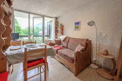 a living room with a couch and a table at Le Pré du bois des Carroz - Proche Aquacîme in Arâches-la-Frasse