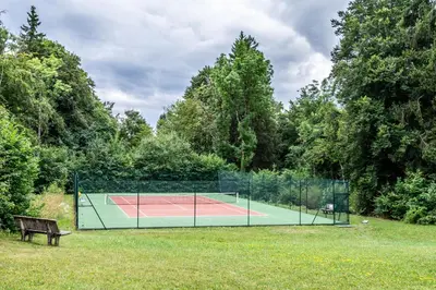 a tennis court in the middle of a park at Le Pré du bois des Carroz - Proche Aquacîme in Arâches-la-Frasse