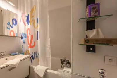 a bathroom with a shower curtain and a sink at Le Pré du bois des Carroz - Proche Aquacîme in Arâches-la-Frasse