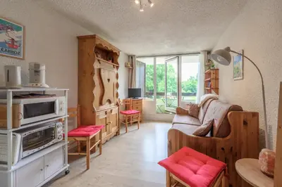 a living room with a couch and a table at Le Pré du bois des Carroz - Proche Aquacîme in Arâches-la-Frasse