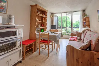a living room with a table and a couch at Le Pré du bois des Carroz - Proche Aquacîme in Arâches-la-Frasse