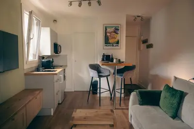 a living room with a couch and a kitchen at Le Perchoir d'Edmond in Chamonix-Mont-Blanc